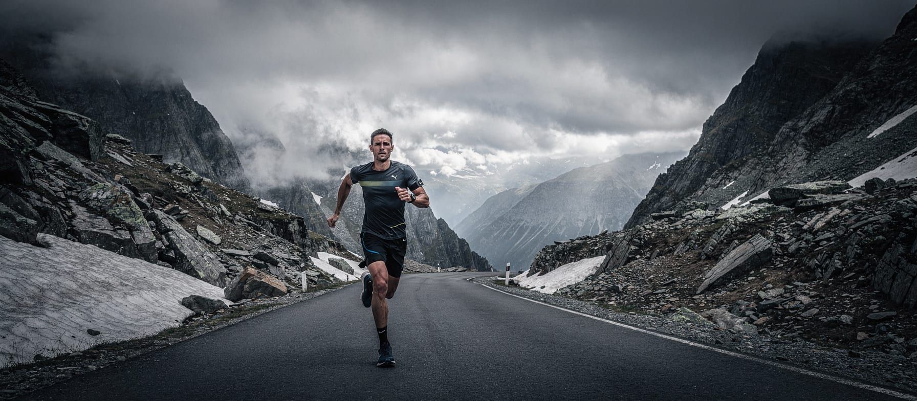 Trail runner ascending a high altitude mountain pass with a beetroot powder container visible in their pack